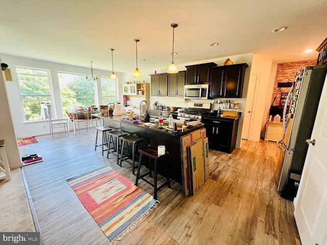 53 Shelduck Ln, Mechanicsburg, PA 17050 - kitchen with stainless steel appliances, light wood-style floors, a kitchen bar, a kitchen island with sink, and hanging light fixtures