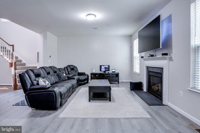 3317 Eagle Ridge Dr, Woodbridge, VA 22191 - living area featuring a glass covered fireplace, wood finished floors, stairs, and baseboards