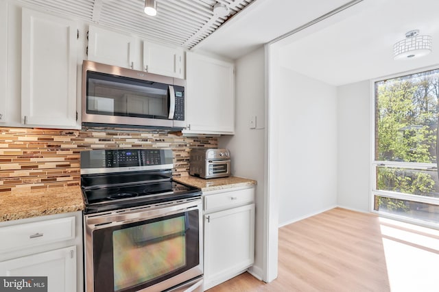 1602 Chimney House Rd Unit 1602, Reston, VA 20190 - kitchen with stainless steel appliances, decorative backsplash, white cabinetry, and light wood-style floors