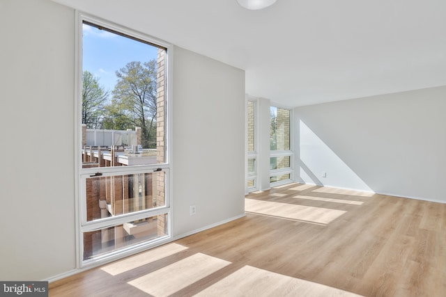 1602 Chimney House Rd Unit 1602, Reston, VA 20190 - unfurnished living room featuring floor to ceiling windows, wood finished floors, and baseboards