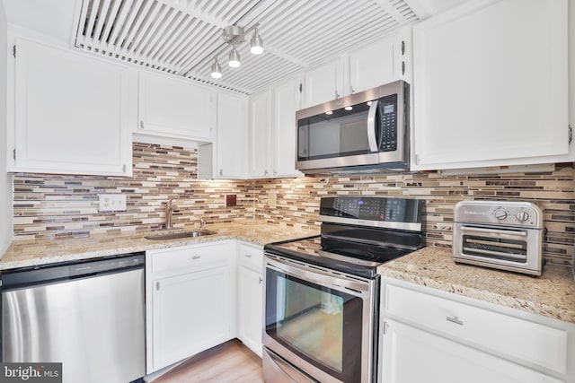 1602 Chimney House Rd Unit 1602, Reston, VA 20190 - kitchen with appliances with stainless steel finishes, a sink, white cabinets, and tasteful backsplash