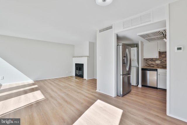 1602 Chimney House Rd Unit 1602, Reston, VA 20190 - unfurnished living room with light wood-style floors, a glass covered fireplace, and baseboards