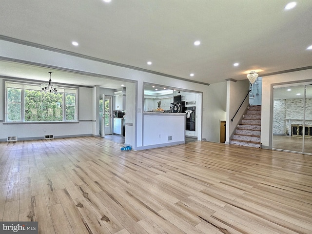 1927 N 15th St, Reading, PA 19604 - unfurnished living room featuring a chandelier, light wood-style flooring, recessed lighting, stairs, and ornamental molding