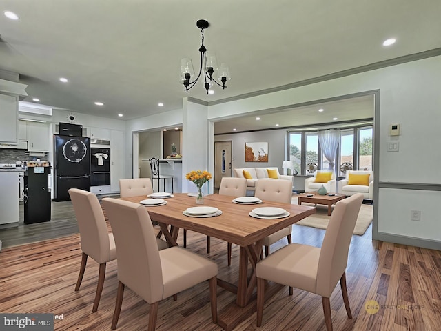 1927 N 15th St, Reading, PA 19604 - dining room with light wood-style flooring, stacked washing machine and dryer, a chandelier, recessed lighting, and crown molding