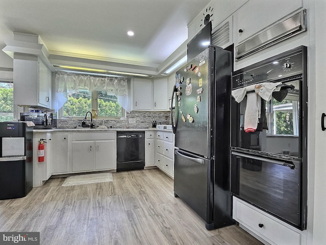1927 N 15th St, Reading, PA 19604 - kitchen featuring black appliances, a sink, light wood-style flooring, white cabinetry, and light countertops