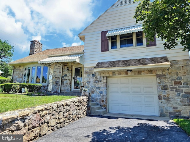 1927 N 15th St, Reading, PA 19604 - view of front of property with stone siding, an attached garage, roof with shingles, driveway, and a chimney