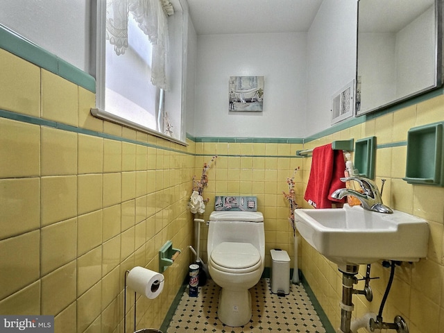 1927 N 15th St, Reading, PA 19604 - bathroom featuring toilet, tile walls, wainscoting, and a sink