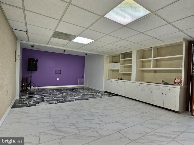 1927 N 15th St, Reading, PA 19604 - unfurnished room featuring light marble finish flooring, baseboards, built in shelves, and a drop ceiling
