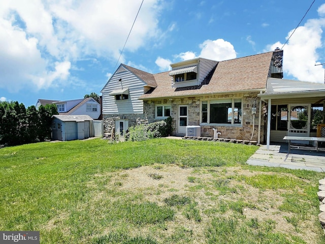 1927 N 15th St, Reading, PA 19604 - rear view of house with stone siding, a yard, cooling unit, roof with shingles, and a patio