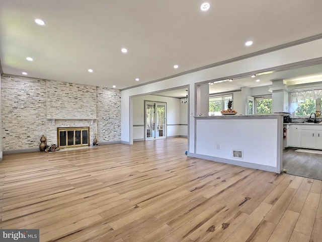 1927 N 15th St, Reading, PA 19604 - unfurnished living room featuring a sink, light wood-style floors, crown molding, recessed lighting, and a fireplace