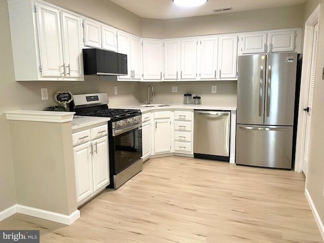 6 Kent Pl, Sewell, NJ 08080 - kitchen featuring appliances with stainless steel finishes, a sink, light wood-style flooring, light countertops, and white cabinets