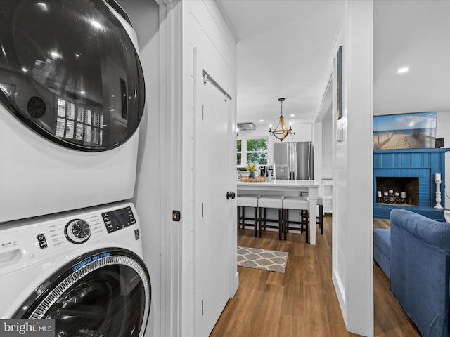 65 W W Ave W, Ocean View, DE 19970 - laundry area featuring estacked washer and dryer, wood finished floors, a chandelier, a fireplace, and recessed lighting