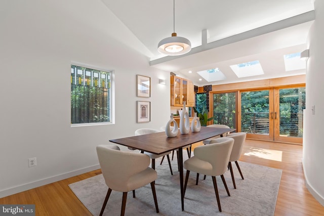 4834 8th St S, Arlington, VA 22204 - dining space with lofted ceiling, a skylight, healthy amount of natural light, light wood-style flooring, and baseboards