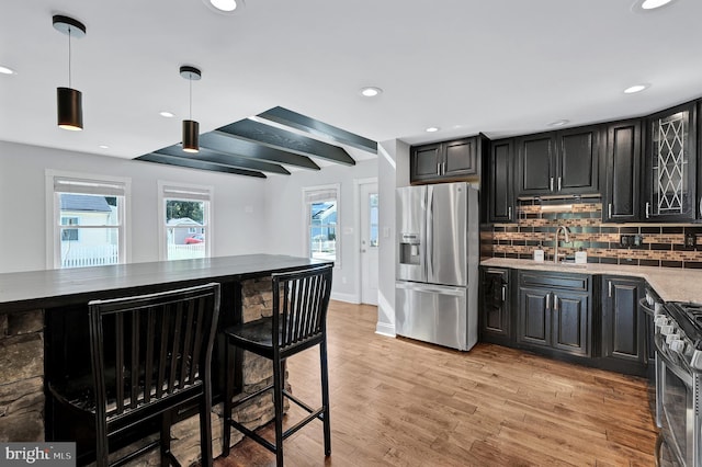 501 Clays Ln, Laurel, MD 20707 - kitchen with appliances with stainless steel finishes, decorative backsplash, light wood-style floors, a sink, and dark cabinetry
