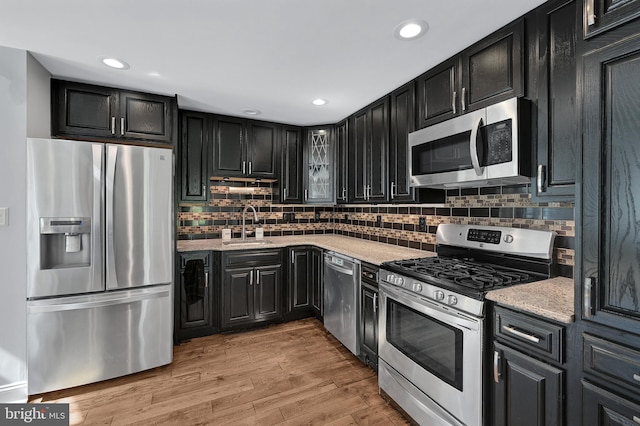 501 Clays Ln, Laurel, MD 20707 - kitchen featuring stainless steel appliances, dark cabinets, a sink, tasteful backsplash, and recessed lighting