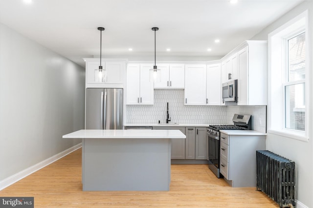 2112 Pine St Unit 2, Philadelphia, PA 19103 - kitchen with appliances with stainless steel finishes, radiator, a sink, a center island, and light countertops
