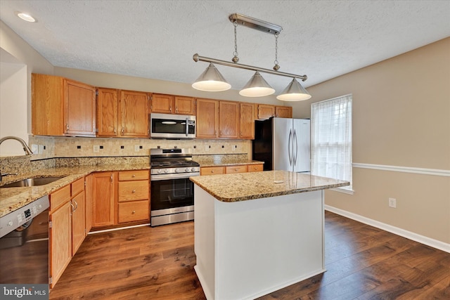 6119 Starburn Path, Columbia, MD 21045 - kitchen featuring appliances with stainless steel finishes, a textured ceiling, backsplash, light stone countertops, and a kitchen island