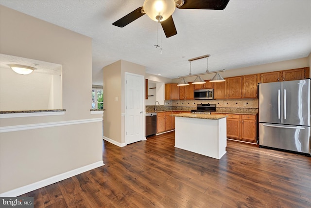 6119 Starburn Path, Columbia, MD 21045 - kitchen featuring appliances with stainless steel finishes, a ceiling fan, dark wood-style flooring, brown cabinetry, and tasteful backsplash