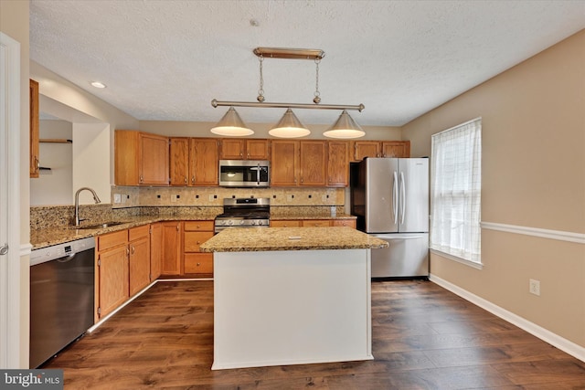 6119 Starburn Path, Columbia, MD 21045 - kitchen featuring appliances with stainless steel finishes, backsplash, light stone counters, a kitchen island, and dark wood-style flooring