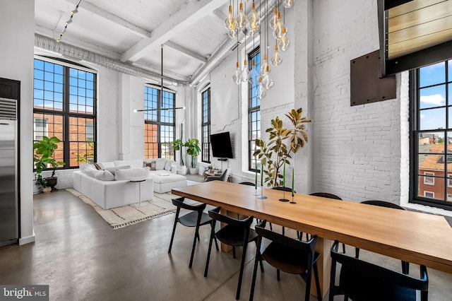 1220 Bank St Unit 304, Baltimore, MD 21202 - dining space featuring a towering ceiling, beamed ceiling, concrete flooring, a chandelier, and brick wall