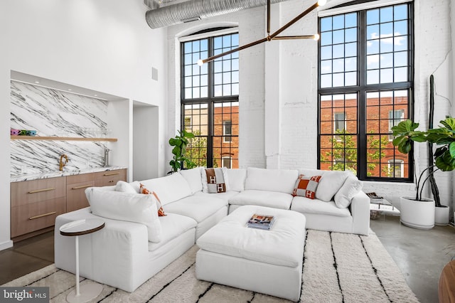 1220 Bank St Unit 304, Baltimore, MD 21202 - living area featuring a high ceiling, finished concrete flooring, and plenty of natural light