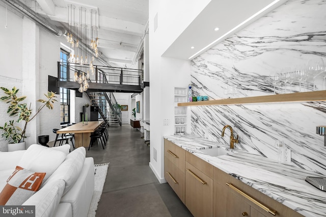 1220 Bank St Unit 304, Baltimore, MD 21202 - bar area featuring finished concrete floors, a sink, a chandelier, stairway, and a high ceiling