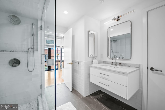 1220 Bank St Unit 304, Baltimore, MD 21202 - bathroom with a tile shower, vanity, recessed lighting, wainscoting, and tile walls