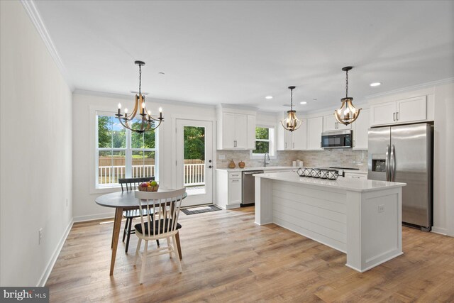 209 S Camden Ave, Fruitland, MD 21826 - kitchen with stainless steel appliances, a chandelier, crown molding, backsplash, and white cabinetry