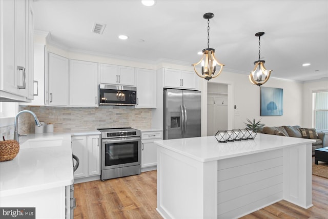 209 S Camden Ave, Fruitland, MD 21826 - kitchen with appliances with stainless steel finishes, light wood-style flooring, white cabinets, backsplash, and light countertops