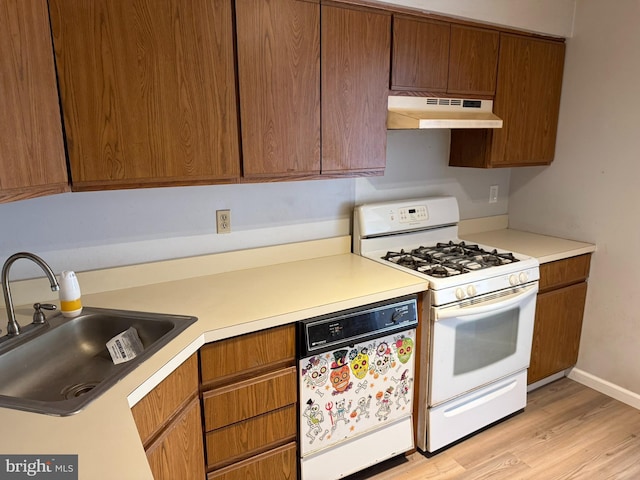 87 Puffin Glade, Bayville, NJ 08721 - kitchen featuring under cabinet range hood, gas range gas stove, dishwashing machine, a sink, and light wood-style flooring