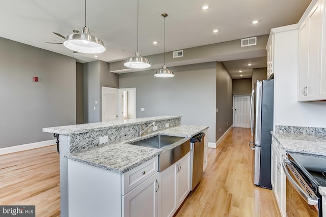1214 Eutaw Pl, Baltimore, MD 21217 - kitchen with appliances with stainless steel finishes, a sink, light wood finished floors, white cabinetry, and recessed lighting