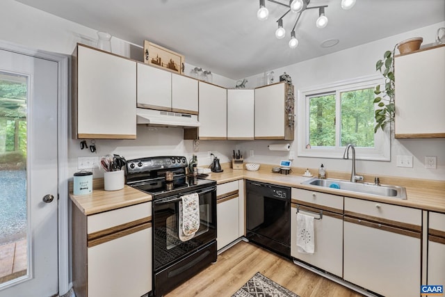 7 Sand Trap Ter, Palmyra, VA 22963 - kitchen featuring black appliances, under cabinet range hood, light countertops, white cabinetry, and light wood-type flooring