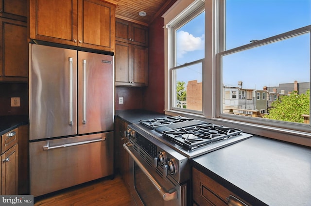 4210 3rd St NW, Washington, DC 20011 - kitchen with appliances with stainless steel finishes, dark countertops, dark wood-style floors, and brown cabinets