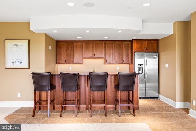 5835 Ridgeview Dr, Doylestown, PA 18902 - kitchen with stainless steel fridge with ice dispenser, recessed lighting, a breakfast bar, baseboards, and brown cabinetry