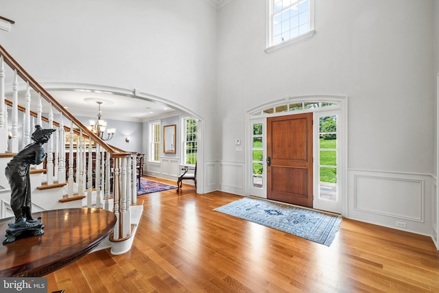 5835 Ridgeview Dr, Doylestown, PA 18902 - foyer entrance featuring arched walkways, stairway, a chandelier, crown molding, and wood finished floors