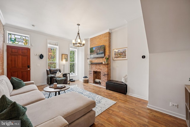 3032 Dillon St, Baltimore, MD 21224 - living room with a chandelier, crown molding, wood finished floors, baseboards, and a brick fireplace