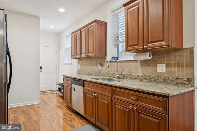 3032 Dillon St, Baltimore, MD 21224 - kitchen featuring a sink, stainless steel dishwasher, freestanding refrigerator, light wood finished floors, and backsplash