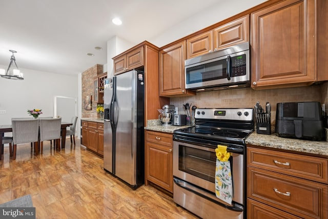 3032 Dillon St, Baltimore, MD 21224 - kitchen featuring stainless steel appliances, brown cabinetry, tasteful backsplash, a chandelier, and recessed lighting