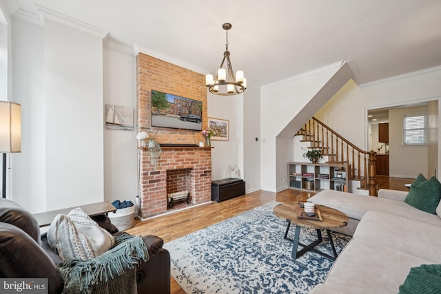 3032 Dillon St, Baltimore, MD 21224 - living area featuring wood finished floors, crown molding, stairs, a chandelier, and a brick fireplace