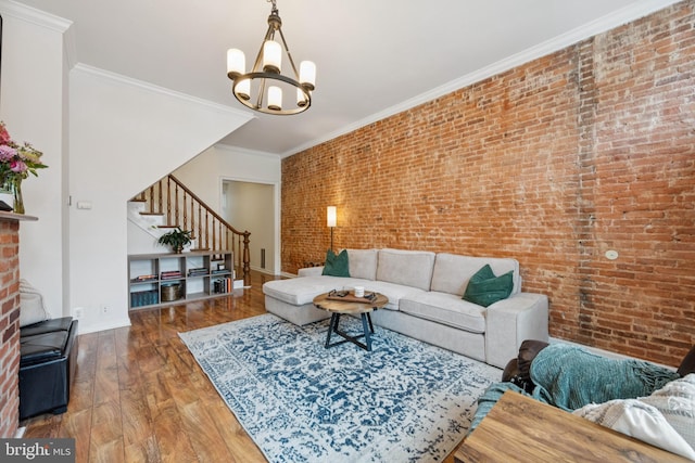3032 Dillon St, Baltimore, MD 21224 - living room with brick wall, stairs, a chandelier, wood finished floors, and baseboards