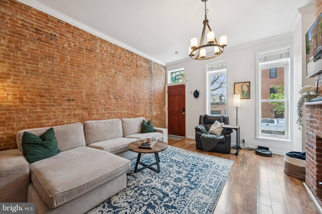 3032 Dillon St, Baltimore, MD 21224 - living area featuring a chandelier, hardwood / wood-style floors, baseboards, ornamental molding, and a brick fireplace