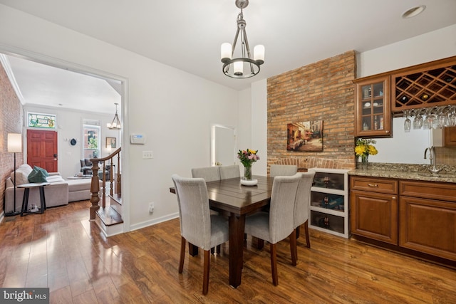3032 Dillon St, Baltimore, MD 21224 - dining room with a chandelier, bar with sink, stairs, and hardwood / wood-style floors