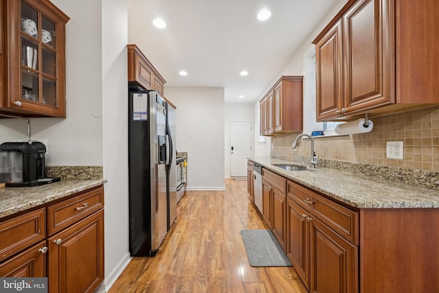 3032 Dillon St, Baltimore, MD 21224 - kitchen featuring appliances with stainless steel finishes, a sink, baseboards, light wood-style floors, and tasteful backsplash