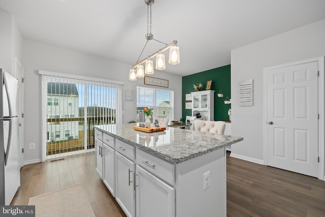 492 Parkland Dr, Stephenson, VA 22656 - kitchen featuring freestanding refrigerator, wood finished floors, white cabinetry, and a center island