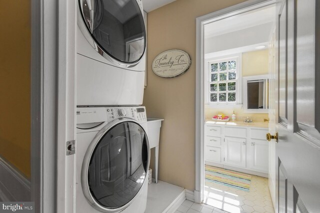 11801 Glen Mill Rd, Potomac, MD 20854 - washroom with stacked washer and clothes dryer, light tile patterned floors, and baseboards