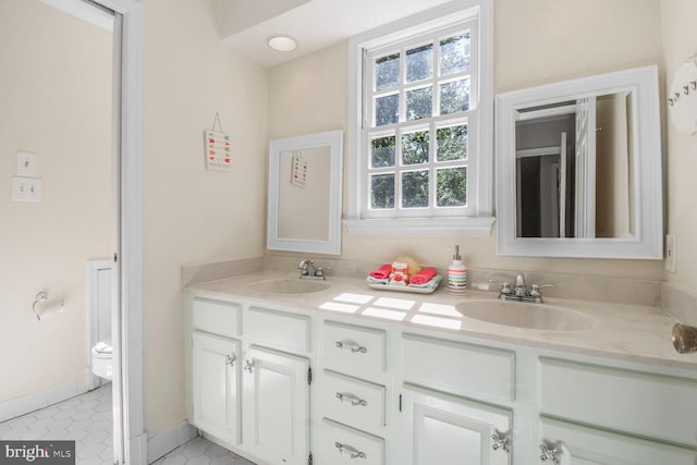 11801 Glen Mill Rd, Potomac, MD 20854 - full bathroom with double vanity, toilet, tile patterned flooring, and baseboards