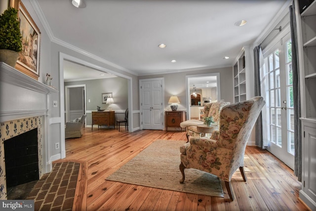 11801 Glen Mill Rd, Potomac, MD 20854 - living area with a tiled fireplace, ornamental molding, light wood-style floors, recessed lighting, and baseboards