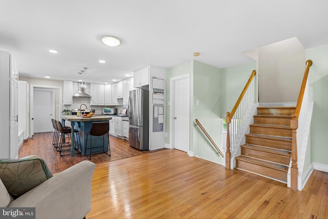 28 New Rd, Doylestown, PA 18901 - kitchen with freestanding refrigerator, white cabinetry, a kitchen breakfast bar, light wood finished floors, and an island with sink