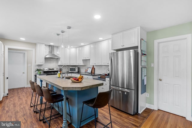28 New Rd, Doylestown, PA 18901 - kitchen featuring stainless steel appliances, wall chimney range hood, a kitchen bar, decorative backsplash, and white cabinetry