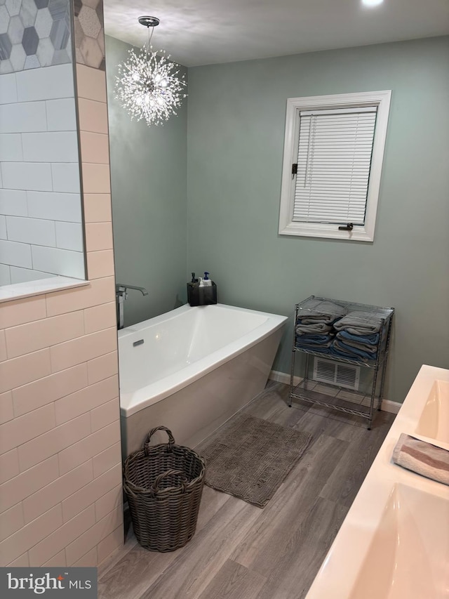 180 E Butler Ave, Vineland, NJ 08360 - bathroom featuring a soaking tub, wood finished floors, double vanity, and a chandelier